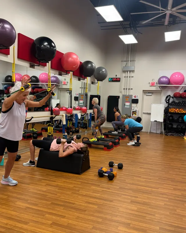 A strength class with dumbbells on the studio floor